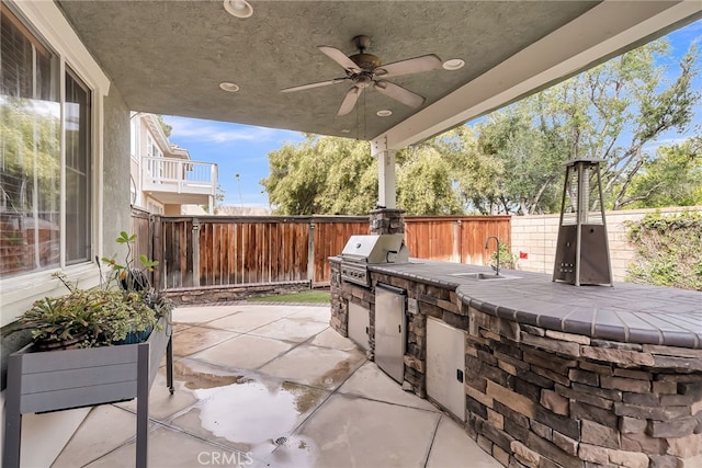 view of patio / terrace featuring area for grilling, a grill, a sink, ceiling fan, and a fenced backyard