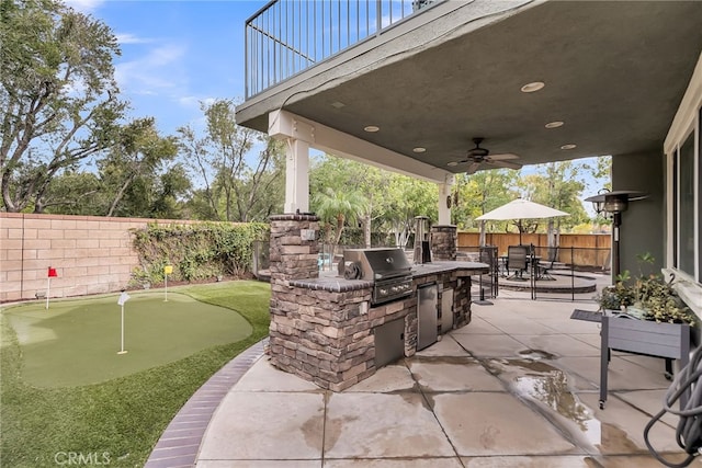 view of patio / terrace featuring outdoor dining area, a grill, ceiling fan, exterior kitchen, and a fenced backyard