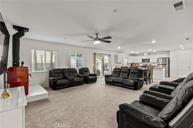 living area with recessed lighting, light colored carpet, ceiling fan, and visible vents