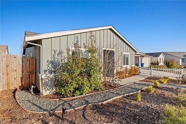 view of side of property with fence and board and batten siding