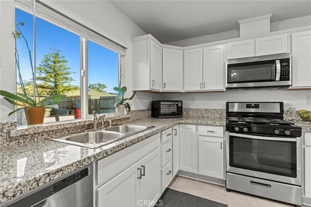 kitchen featuring a toaster, white cabinetry, stainless steel appliances, and a sink