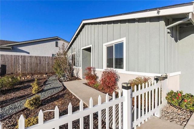 view of side of property featuring a fenced front yard and board and batten siding