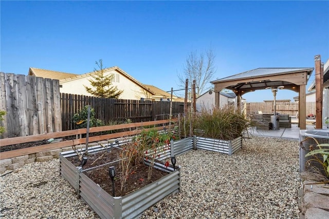 view of yard featuring a patio area, a fenced backyard, a vegetable garden, and a gazebo