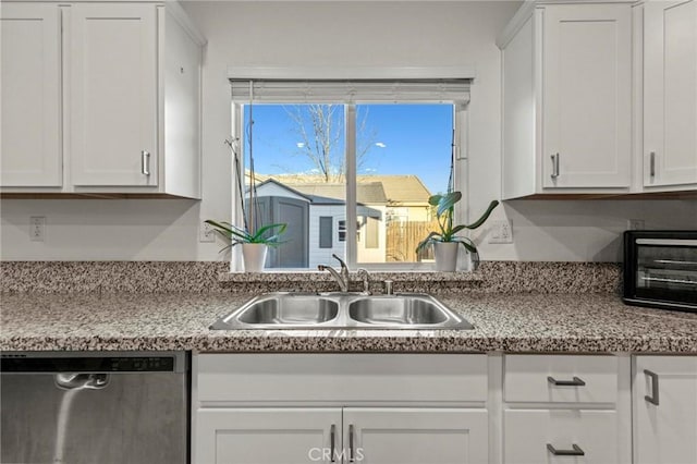 kitchen featuring light countertops, white cabinets, dishwasher, and a sink