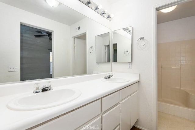 bathroom with double vanity, walk in shower, a sink, and visible vents