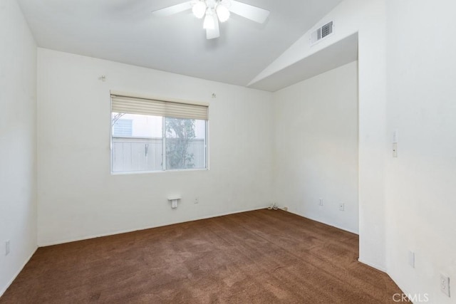 carpeted spare room featuring visible vents, vaulted ceiling, and ceiling fan