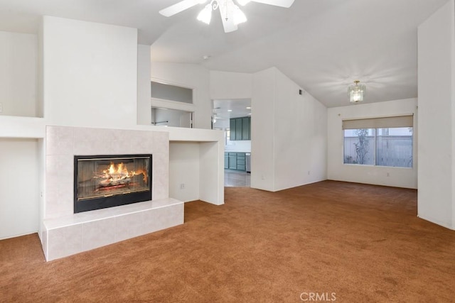 unfurnished living room featuring carpet floors, vaulted ceiling, a fireplace, and ceiling fan