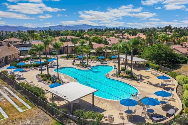 pool featuring a patio area, a mountain view, and fence