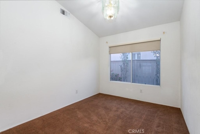 empty room featuring visible vents and dark colored carpet