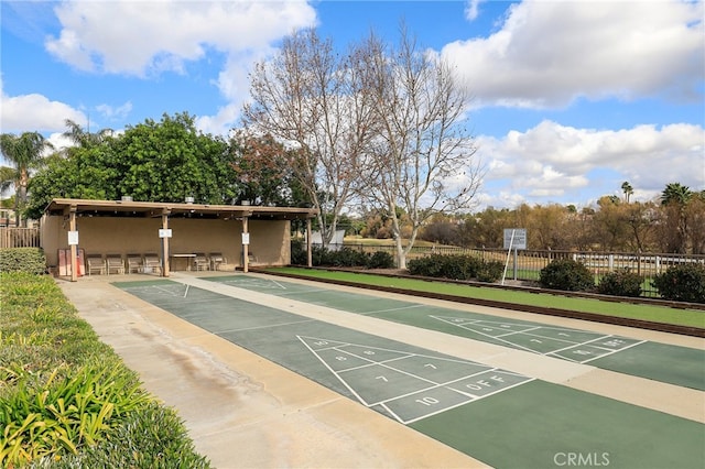 view of home's community featuring fence and shuffleboard