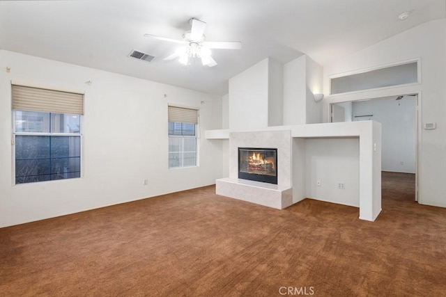 unfurnished living room featuring visible vents, a ceiling fan, lofted ceiling, a premium fireplace, and carpet flooring