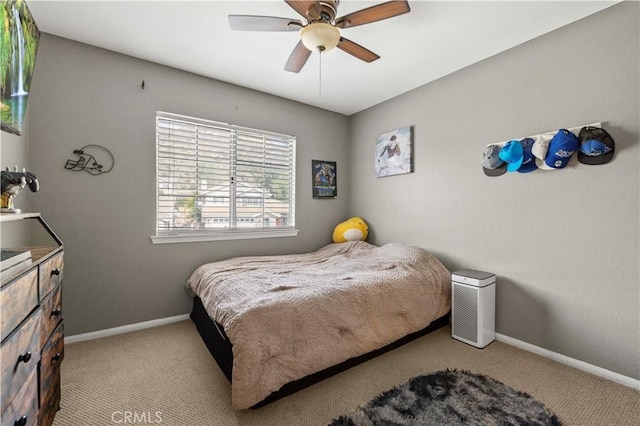 bedroom featuring a ceiling fan, light colored carpet, and baseboards