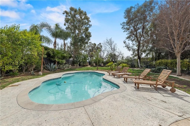 outdoor pool with a patio area and fence