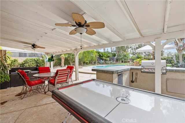 view of patio with an outdoor kitchen, a ceiling fan, outdoor dining space, a grill, and fence