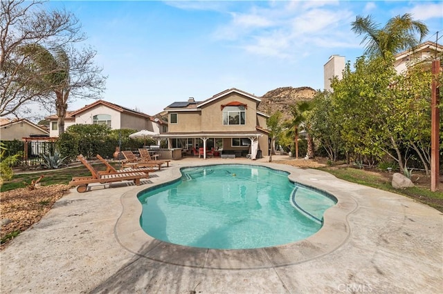 pool with a patio area and fence