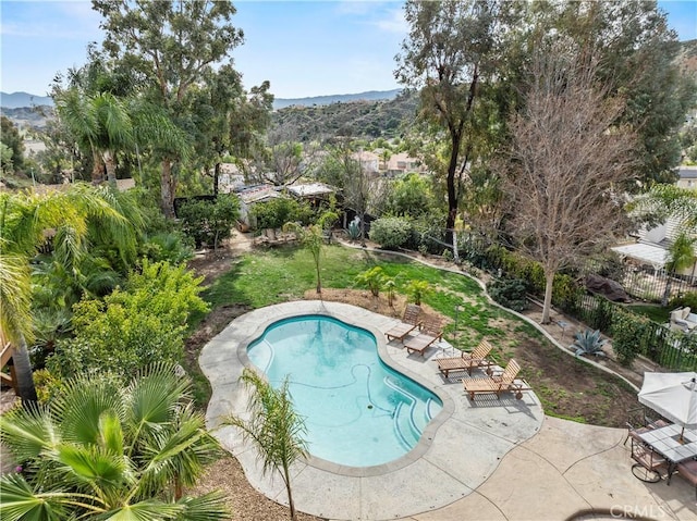 view of swimming pool with fence, a mountain view, a fenced in pool, and a patio