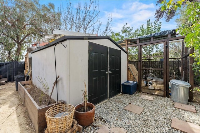 view of shed featuring fence private yard and a garden