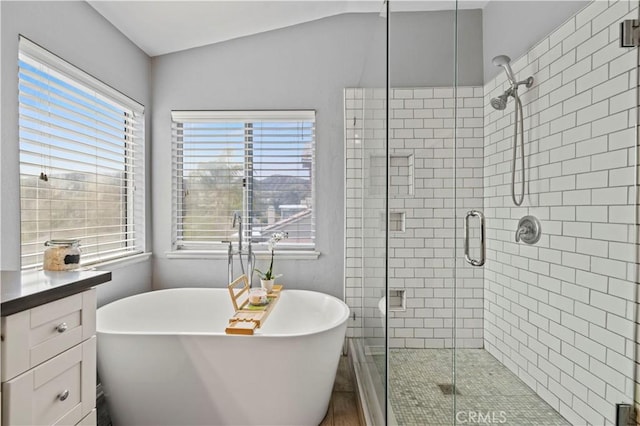 bathroom with a stall shower and a soaking tub