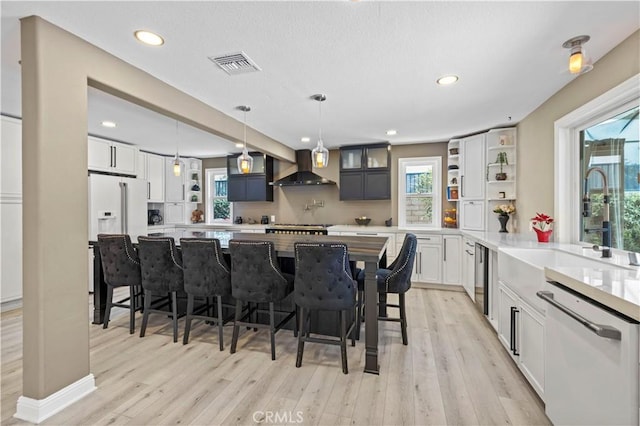 kitchen with white appliances, a sink, visible vents, wall chimney range hood, and open shelves