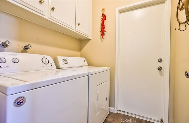 clothes washing area with dark wood-style floors, washing machine and dryer, and cabinet space