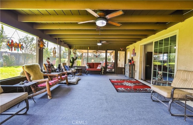 sunroom with a ceiling fan and beamed ceiling