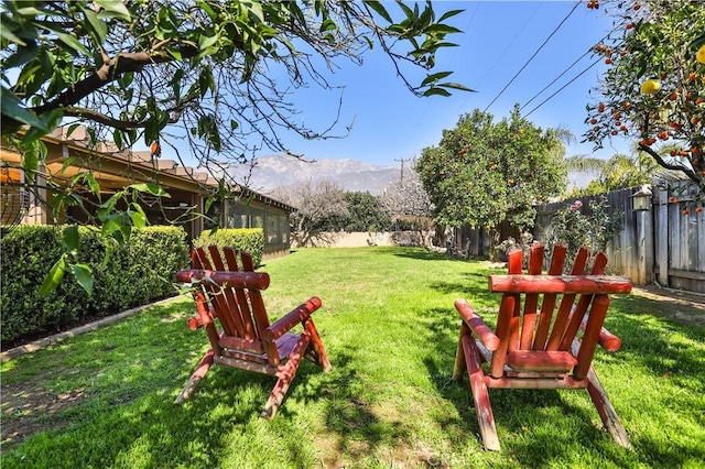 view of yard with a fenced backyard and a mountain view