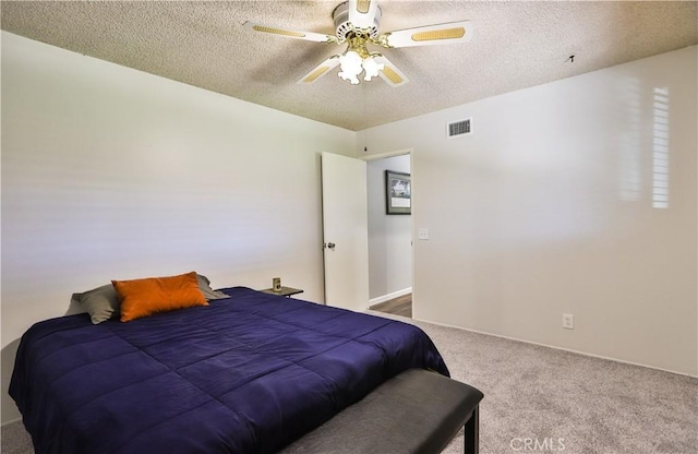 carpeted bedroom with a textured ceiling, visible vents, and a ceiling fan