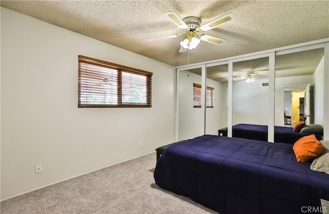 bedroom featuring a textured ceiling, a ceiling fan, and carpet flooring