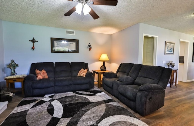 living room with visible vents, ceiling fan, a textured ceiling, and wood finished floors