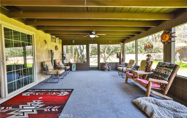 sunroom featuring a ceiling fan and beam ceiling