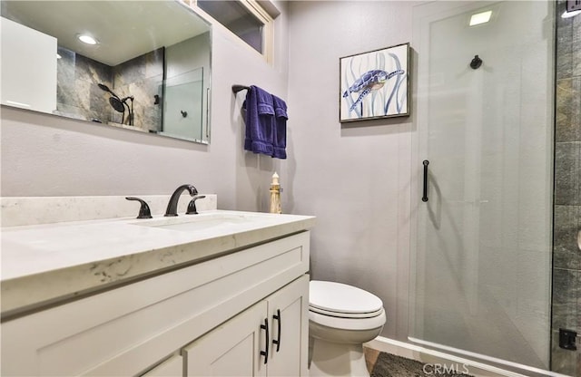 full bath featuring vanity, a shower stall, and toilet