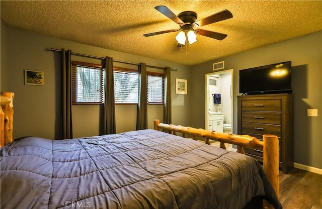 bedroom featuring a textured ceiling, visible vents, wood finished floors, and ensuite bathroom