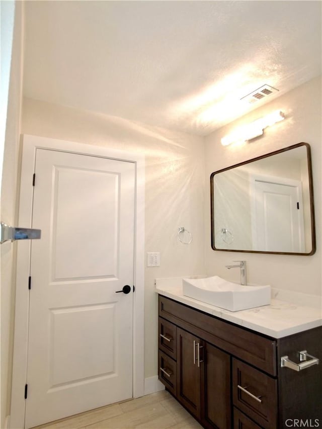 bathroom with visible vents, wood finished floors, and vanity