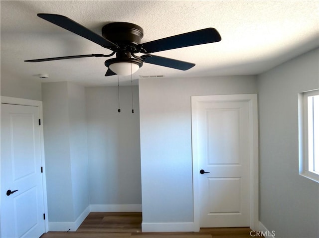 unfurnished bedroom with baseboards, visible vents, ceiling fan, and wood finished floors