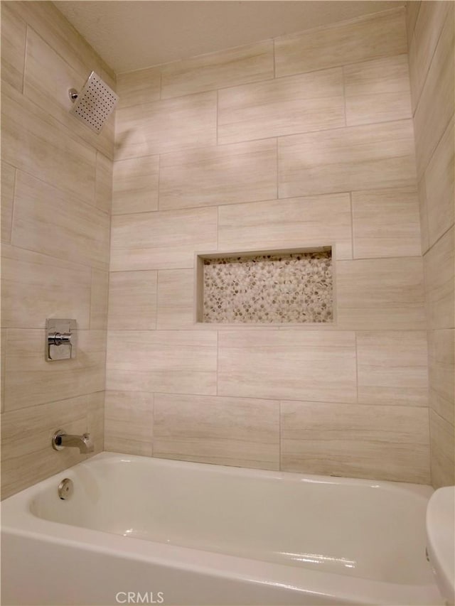 bathroom with bathing tub / shower combination and toilet