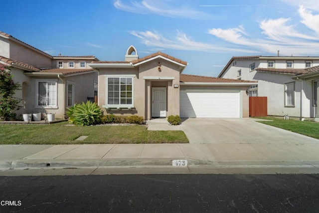 mediterranean / spanish-style house featuring driveway, a garage, a tiled roof, a front lawn, and stucco siding