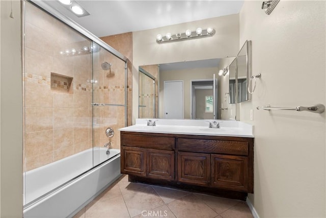 full bathroom with bath / shower combo with glass door, double vanity, and tile patterned flooring