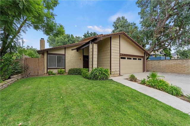 view of front of house featuring a garage, fence, concrete driveway, a chimney, and a front yard