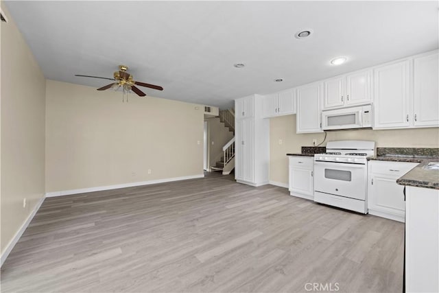 kitchen with light wood-style floors, white appliances, white cabinets, and baseboards