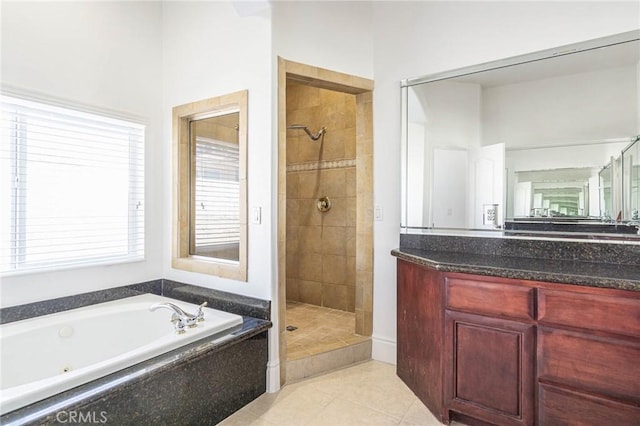 bathroom featuring tile patterned flooring, a shower stall, a bath, and vanity