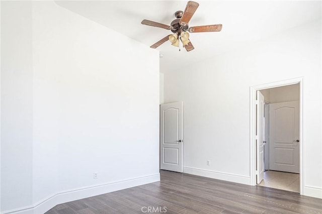 empty room featuring a ceiling fan, baseboards, and wood finished floors