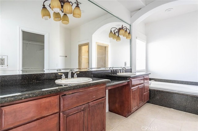 full bathroom featuring double vanity, a garden tub, tile patterned flooring, and a sink