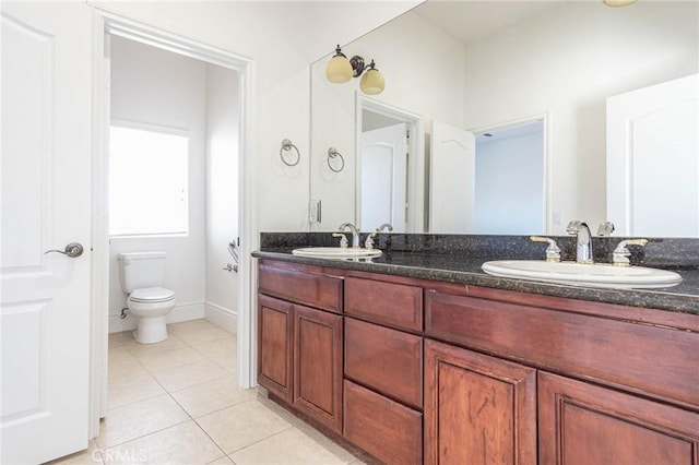 bathroom with tile patterned flooring, a sink, toilet, and double vanity