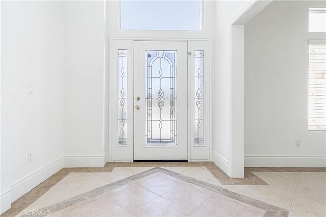 entryway featuring baseboards and light tile patterned floors