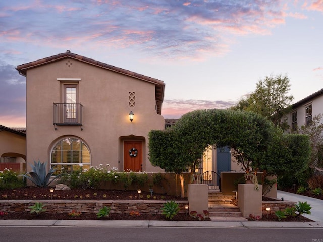 mediterranean / spanish house with driveway, a tiled roof, and stucco siding