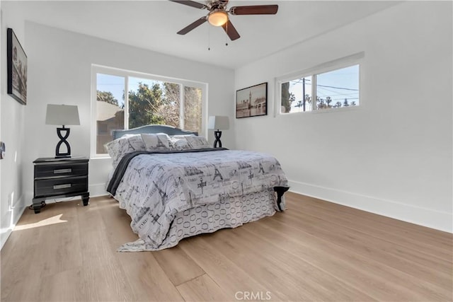 bedroom featuring a ceiling fan, wood finished floors, and baseboards