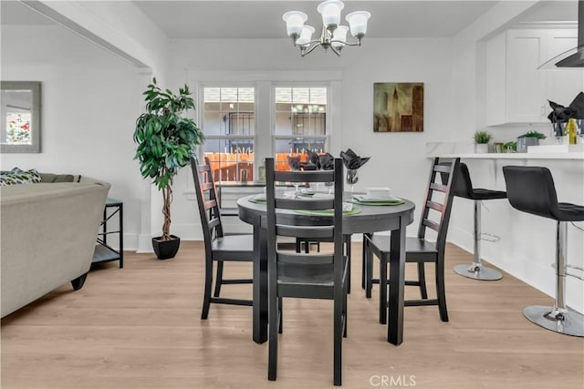 dining space with a notable chandelier and light wood-style floors