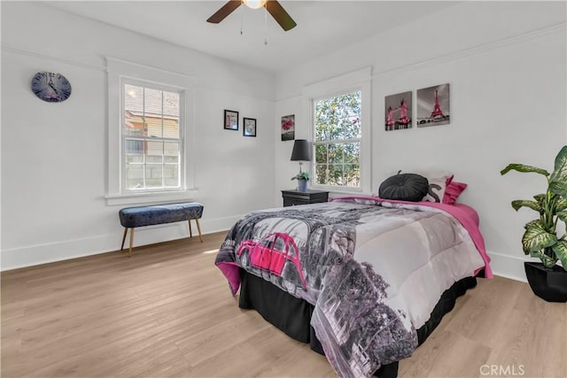 bedroom with a ceiling fan, baseboards, and wood finished floors