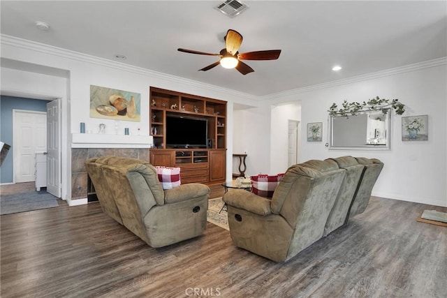 living room featuring ornamental molding, wood finished floors, visible vents, and a ceiling fan