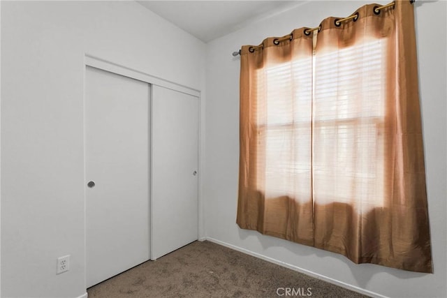 unfurnished bedroom featuring carpet floors and a closet